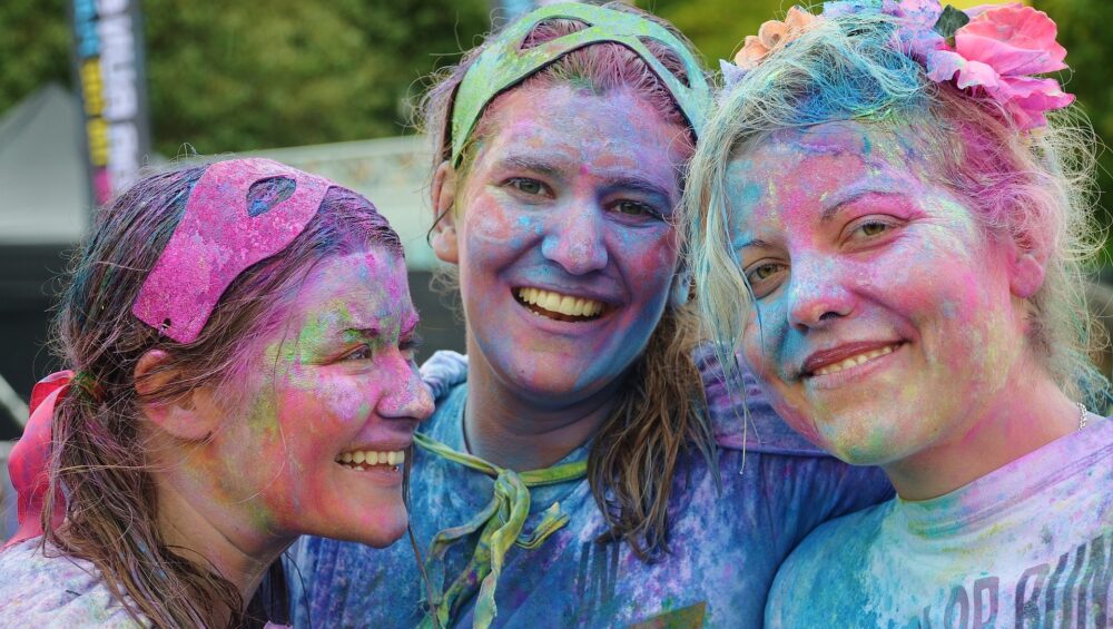 Groupe d’amies souriantes couvertes de couleurs après la fête Holi en Inde