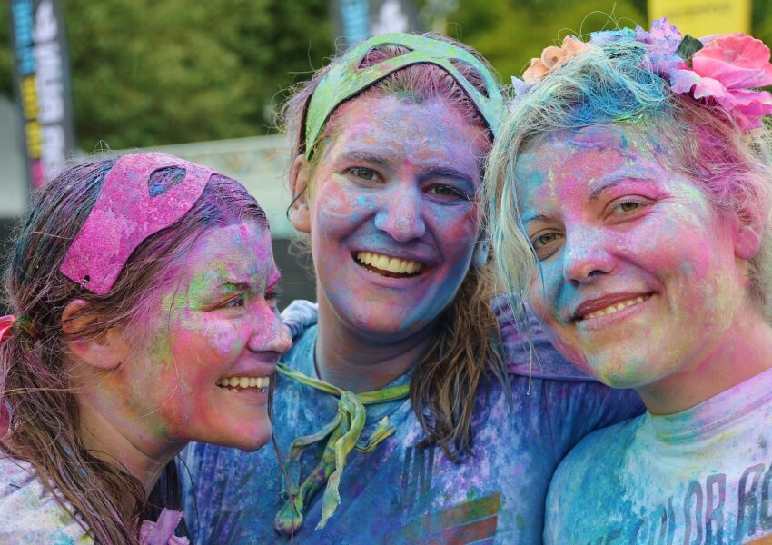 Groupe d’amies souriantes couvertes de couleurs après la fête Holi en Inde